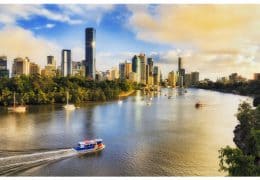 Colourful sunrise and soft morning sun light in Brisbane city over Brisbane river and high-rise CBD towers from elevation of Kangaroo point and Cliffs park.